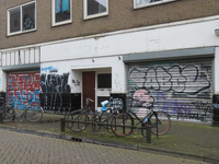 829239 Gezicht op de voorgevel van het pand Draaiweg 81 te Utrecht, met graffiti op de rolluiken en op de muur.